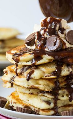 a stack of pancakes covered in chocolate syrup