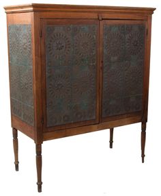 an old wooden cabinet with metal panels on the doors and legs, against a white background