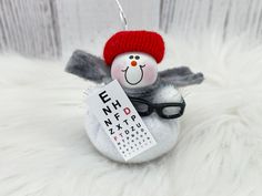 a snowman ornament with eyeglasses and a name tag on it