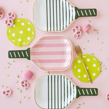 three plates with pink and green designs on them, one has a fork in the middle