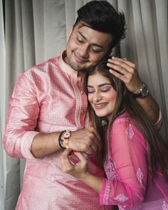 a man in a pink outfit standing next to a woman