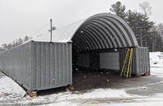 two portable buildings in the snow near some trees