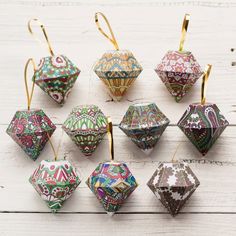 twelve ornament ornaments are arranged on a white wooden surface