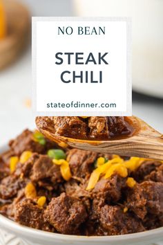 a white bowl filled with beef and cheese next to a wooden spoon that says no bean steak chili