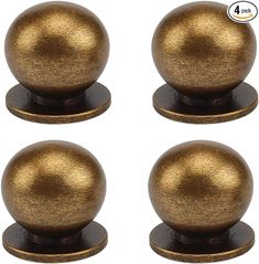 four brass colored knobs on black bases