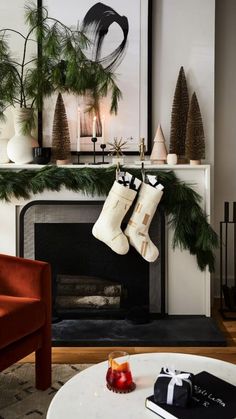 christmas stockings hanging from a fireplace mantel in front of a fire place with candles