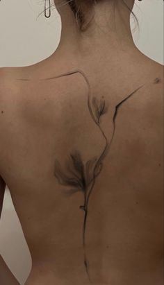 the back of a woman's body with tattoos on it