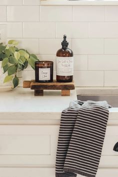 a bottle of liquid sitting on top of a counter next to a towel