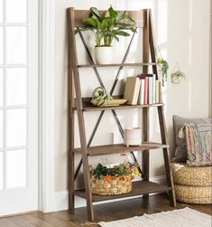 a shelf with books, plants and other things on it next to a chair in a room