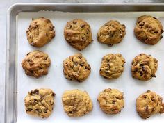 twelve chocolate chip cookies on a baking sheet