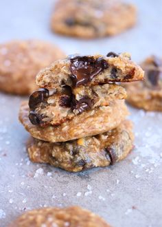 chocolate chip cookies stacked on top of each other with one cookie broken in the middle