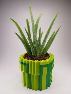 a green plant in a pot made out of legos