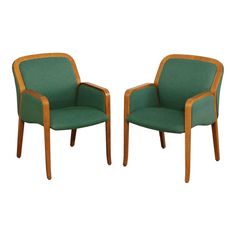 two green upholstered chairs with wood trimmings on each arm and back