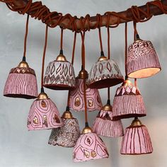 a bunch of pink lamps hanging from a ceiling