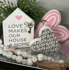 two heart shaped wooden signs sitting on top of a table next to some balls and twine