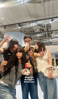 group of young people taking selfies in an indoor mall or shopping area with their cell phones