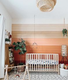 a baby's room with a crib, rug and potted plant in the corner