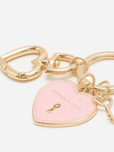 a heart shaped keychain with a lock on the front and a pink tag on the back