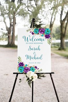 a welcome sign with purple and blue flowers on it