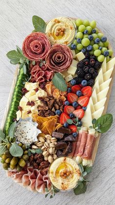 a platter filled with different types of cheeses and meats on top of each other