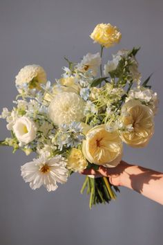 a person holding a bouquet of flowers in their hand