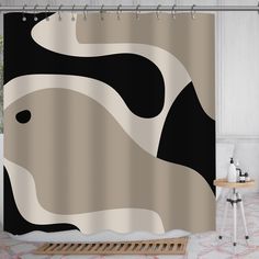 a shower curtain with a black and white abstract design on the front, in a bathroom