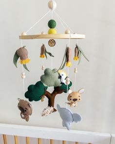 a crib mobile with animals hanging from it's sides