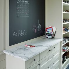 a chalkboard in the corner of a walk - in closet with shoes on it