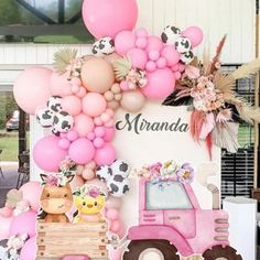 there is a pink tractor with balloons and animals on the back, along with other decorations