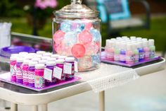 there are many candies on the table and one has a glass jar with candy in it