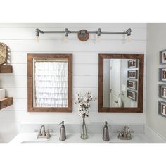 a bathroom sink with two mirrors above it and pictures on the wall next to it