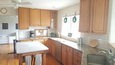 a kitchen with wooden cabinets and white counter tops in front of a clock on the wall