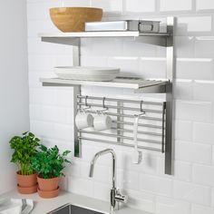 a kitchen sink with a shelf above it and some pots on the counter next to it