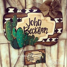 a wooden sign that says john beckan with a cactus on it and a bow