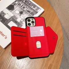 an iphone case sitting on top of a wooden table next to a book and magazine