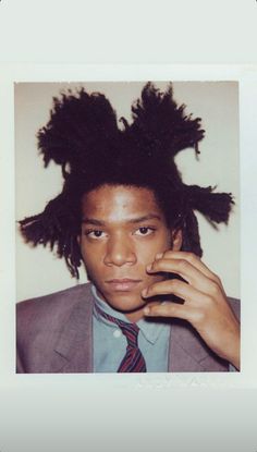 a man with dreadlocks on his head talking on a cell phone while wearing a suit and tie