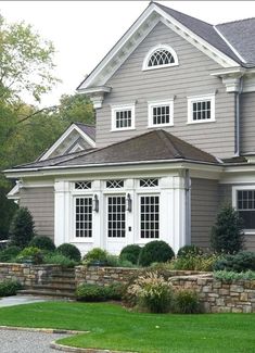 a large gray house with white trim and windows