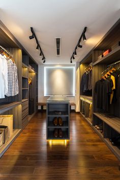 a large walk in closet with wooden floors