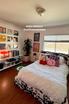 a bed room with a neatly made bed and lots of pictures on the wall