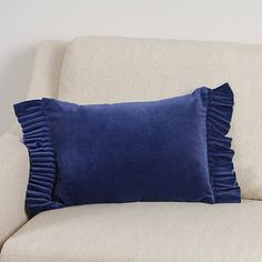 a blue pillow sitting on top of a white couch