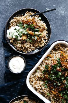 two bowls filled with rice and vegetables on top of a blue cloth next to a bowl of sour cream