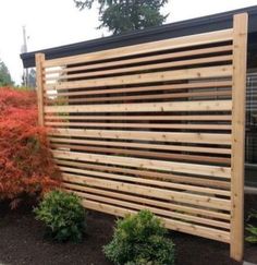 a wooden fence in front of some bushes