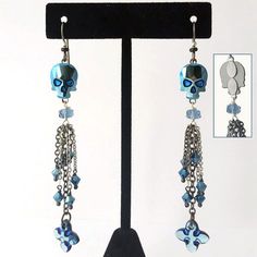 a pair of earrings with blue beads and skulls hanging from it's ear wires