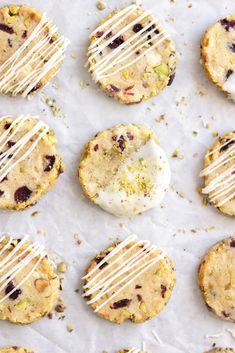 cookies with white icing and cranberry toppings on a sheet of wax paper