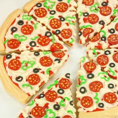 a pizza cut into eight slices with green and red toppings on the top, sitting on a white surface