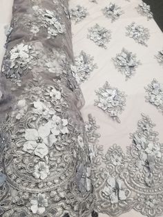 This Beautiful 3D Embroidered Satin Floral Pearl fabric is one of a kind. The fabric is backed with a mesh fabric and a gorgeous embroidered floral design, that gives off a 3D illusion. There are Pearls that have been stapled on to the fabric to give a gorgeous and eye catching design. Fabric is sold by the yard and if more than one yard is purchased, it will come in one piece. White satin is used for the backing of the fabric in images only, not included in the fabric. Width: 52" Uses: Apparel, Pearl Fabric, Table Skirt, Bridal Fabric, 3d Illusion, Wedding Lace, Design Fabric, Lace Weddings, White Satin, Fabric Width