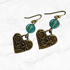 These delightful earrings feature bronze hearts and a heart charm with dragonfly dangling gracefully from aqua glass beads. The combination of earthy bronze tones and vibrant aqua creates a pretty coastal cowgirl look. Whether you're strolling along the beach or dancing under the stars, these earrings add a touch of whimsy and elegance to any outfit. Lightweight everyday earrings for casual or dressy occasions.  Artisan glass beads produced in small quantities in the Czech Republic Hypoallergeni Gift Bronze Beaded Earrings, Bronze Dangling Beads Earrings For Gift, Bronze Earrings With Dangling Beads For Gift, Adjustable Bronze Beaded Earrings As Gift, Bronze Beaded Earrings As Gift, Bronze Beaded Earrings For Gift, Beaded Bronze Earrings For Gift, Handmade Brass Heart Dangle Earrings, Whimsical Nickel-free Heart Earrings