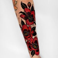 a woman's leg with red flowers and butterflies tattoo on her left calf area