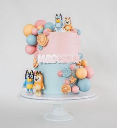 a cake decorated with cartoon characters and balloons