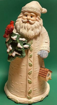 a ceramic figurine of santa holding a bird